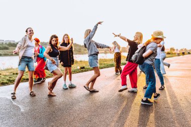 Parti orta yaşlı kadınlar, milenyum, gün batımında. Grup dansı, neşeli, çekici, mutlu kadınlar, yaz, tatil, seyahat. Gün batımında dans eden neşeli ve çekici kadınlar. 