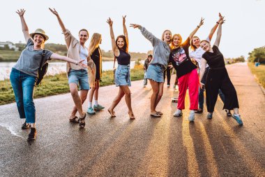 Parti orta yaşlı kadınlar, milenyum, gün batımında. Grup dansı, neşeli, çekici, mutlu kadınlar, yaz, tatil, seyahat. Gün batımında dans eden neşeli ve çekici kadınlar. 