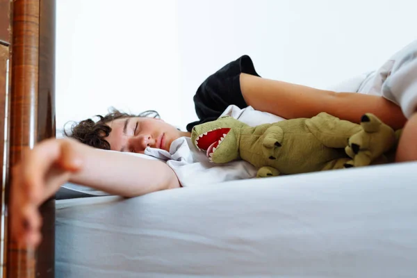 Nastolatka Śpiąca Łóżku Przytulająca Ulubioną Zabawkę Dinozaura Wisząca Ręka Łóżka — Zdjęcie stockowe