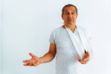 Kırık kollu orta yaşlı bir adam, şaşırmış ya da yanlış anlaşılmış.