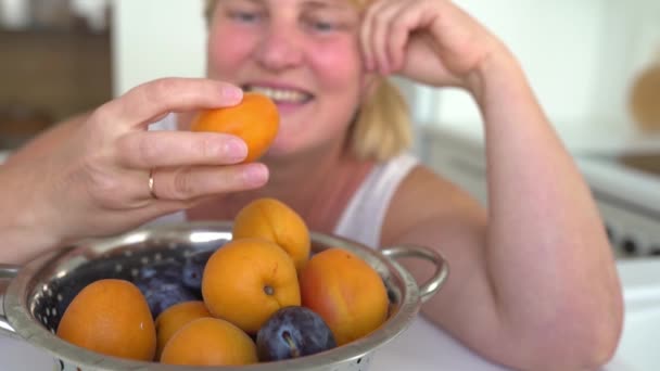 Glad Medelålders Kvinna Blond Fyllig Äter Mogen Stor Aprikos Med — Stockvideo