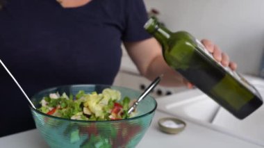 Ev mutfağında domates, ıspanak, zeytinyağı ve mozzarella salatası yapıyorum. Kadın salata baharatları biber, zeytin yağı, soya sosu ekliyor..