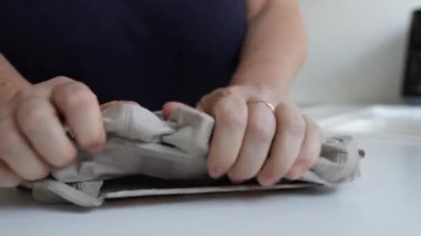 Kadınların elleri kağıda geri dönüşüm yapmak için bir yumurta kutusunu kağıttan çıkarır. Evde atık ayrımı, sıfır atık, yer ayır