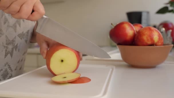 把苹果切成薄片以便进一步烘干 女手用菜刀把成熟的大苹果切成薄片铺在烤盘上 — 图库视频影像