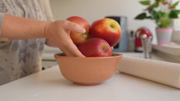 Mujer Pone Grandes Manzanas Rojas Lavadas Maduras Tazón Cerámica Cocina — Vídeo de stock