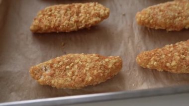 Fırın tepsisinde çiğ, donmuş tavuk parçaları. Ev yapımı nugget 'lar için yarı bitmiş ürünler