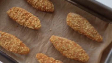 Fırın tepsisinde çiğ, donmuş tavuk parçaları. Ev yapımı nugget 'lar için yarı bitmiş ürünler