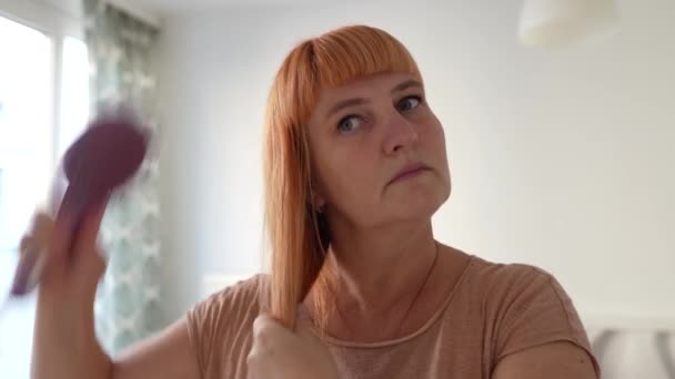Attraktive Midaldrende Kvinde Kæmning Langt Rødt Hår Close Mod Sløret – Stock-video