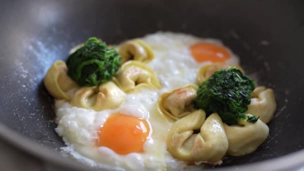 フライパンにトルテリーニとほうれん草の揚げ卵 ランチ スローモーション 栄養価の高い食べ物 — ストック動画