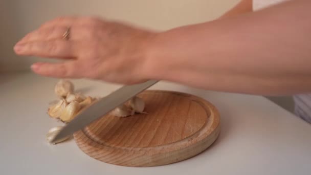 Frau Schält Und Hackt Knoblauch Auf Holzbrett Weiter Kochen — Stockvideo