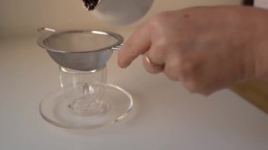 Kahve demliğinden süzgeç yoluyla fincana taze kahve dök. Kahve filtresi.