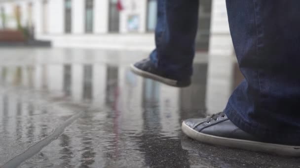 Figura Irreconocible Adolescente Jeans Zapatillas Deporte Impermeable Amarillo Camina Través — Vídeo de stock