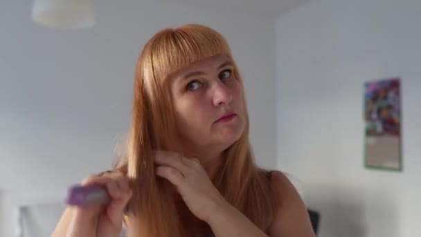 Женщина Средних Лет Ухаживает Длинными Рыжими Волосами Расчесывает Кисточкой Улыбается — стоковое видео