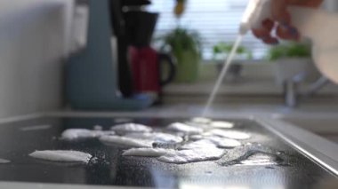 Kadınların elleri mutfak yüzeyini temizlik süngeri ve fırın deterjanıyla yıkıyor. Pişirdikten sonra mutfağı temizlemek, anti-yağ maddesi.