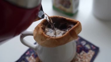 Ev mutfağında kağıt filtre kullanarak kahve demleme işlemi. Kahve yapmak için alternatif yollar..