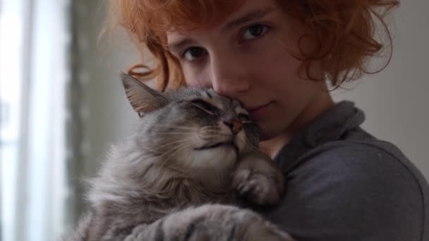 滑稽的红头发少女抱着宠物在怀里 拥抱和亲吻着缅因州的猫 宠物与它的主人猫妈妈之间的友谊 — 图库视频影像