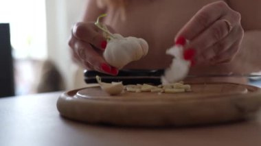 Kadınlar sarımsak ve yeşil lahanaları büyük mutfak bıçağıyla kesiyor.