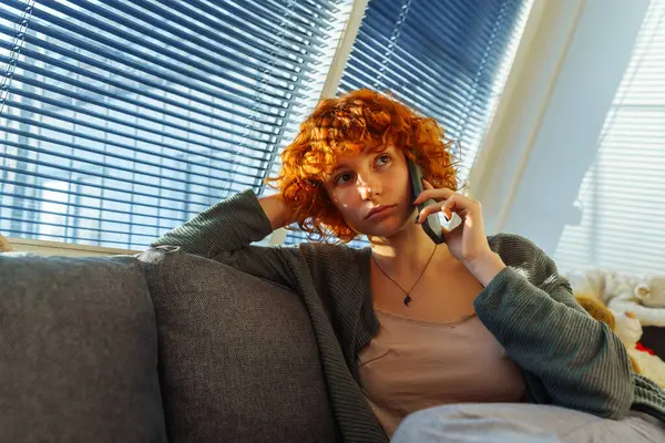 집에서 편안한 소파에 앉아있는 전화를 사용하여 초상화 블라인드와 향수적인 블라인드의 — 스톡 사진