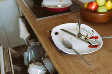 Ahşap mutfak tezgahında bulaşık makinesiyle kirli bulaşıklar kullanırdı. Modern mobilya, mutfak temizliği konsepti