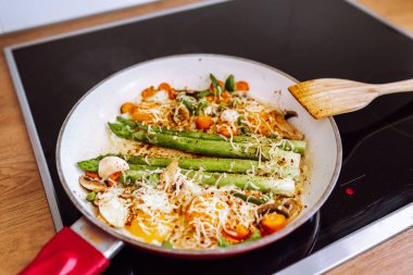 Kızarmış yeşil kuşkonmaz, kızarmış tavada peynir ve yumurta, sağlıklı beslenme kahvaltısı.