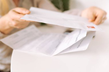 Kadınların elleri zarfı elinde tutuyor, yakın plan, uyarı, banka hesabı, hafif odaklanma.