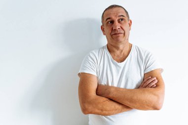 Beyaz arka planda orta yaşlı bir adam portresi, burnunu kırıştırıyor, yüzünü buruşturuyor, sırıtarak kameraya bakıyor, gülümsüyor.,