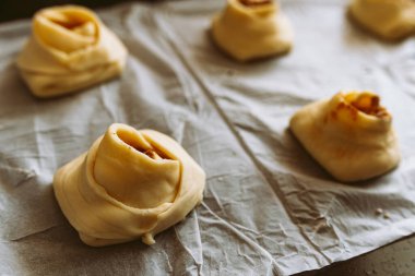 Tarçınlı ve şekerli rulo fırında pişirin. Tarçınlı rulo yapma işlemi. Hamur ekmek çarşafında, çörek şeklinde.