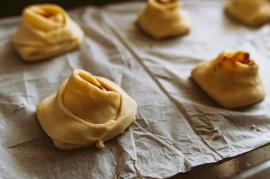 Tarçınlı ve şekerli rulo fırında pişirin. Tarçınlı rulo yapma işlemi. Hamur ekmek çarşafında, çörek şeklinde.