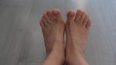 Kadınlar yalınayak, ayak parmaklarının eklemlerini ısıtmak, ayak için yoga. Ayaklarını yere yakın tut.