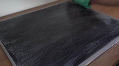 Kadınların elleri cam yüzeyi yıkar elektrikli soba ya da deterjanla indüksiyon sobası temizler, cam ve süngerle yemek hazırlığını izler.