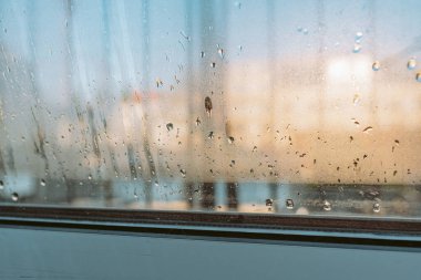 Çift camlı pencerede yoğunlaşma oluşuyor. Soğuk hava ve nem kontrastı. Cama damlıyor. Soğuk oda. Arka ışıklandırma zavallı cam kaplama.