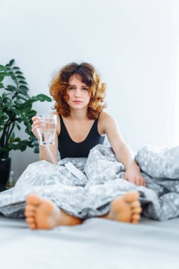 Baş ağrısı, akşamdan kalma, bulantı, grip ve makyajlı genç bir kadın.