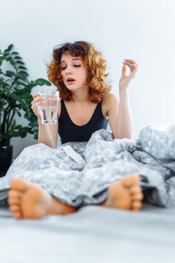 Baş ağrısı, akşamdan kalma, bulantı, grip ve makyajlı genç bir kadın.