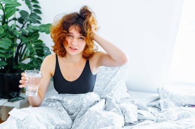 Baş ağrısı, akşamdan kalma, bulantı, grip ve makyajlı genç bir kadın.