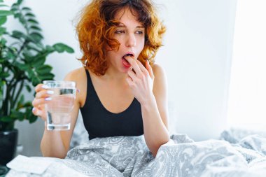 Baş ağrısı, akşamdan kalma, bulantı, grip ve makyajlı genç bir kadın.