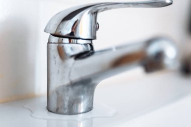 Tesisat musluğu tamiri. Hasarlı krom kaplamalı eski musluk, sızdıran conta.