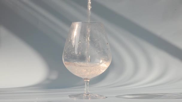 ガラスに水を注ぐプロセス 白い背景に水のガラス トップビュー コピースペース 平置きだ 健康的なライフスタイル 食べ物と飲み物 — ストック動画