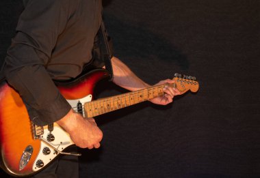 Vaduz, Lihtenştayn, 28 Eylül 2022 Müzisyen Fender Stratocaster ABD standart elektro gitarını çalıyor 1995 yılında güneş patlaması renginde