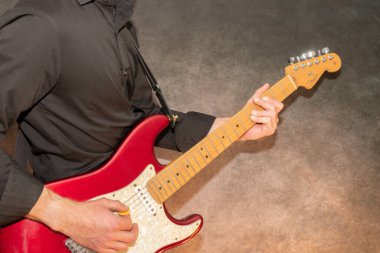Vaduz, Lihtenştayn, 23 Aralık 2022 Müzisyen kırmızı renkli Fender Stratocaster ABD elektro gitarı çalıyor.