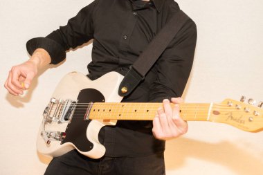 Vaduz, Lihtenştayn, 23 Aralık 2022 Müzisyen, Japonya 'da üretilen büyük bir tremolo sistemiyle beyaz Fender Telecaster elektro gitar çalıyor.