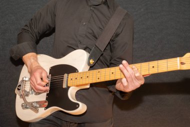 Vaduz, Lihtenştayn, 23 Aralık 2022 Müzisyen, Japonya 'da üretilen büyük bir tremolo sistemiyle beyaz Fender Telecaster elektro gitar çalıyor.