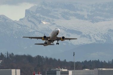 Zürih, İsviçre, 23 Aralık 2022 Vueling Airbus A320-214, yağmurlu bir günde 32 numaralı pistten kalkıyor.