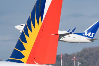 Zurich, Switzerland, January 19, 2023 SAS Scandinavian airlines Boeing 737-705 aircraft is taking off behind the rudder of a philippines Boeing 777