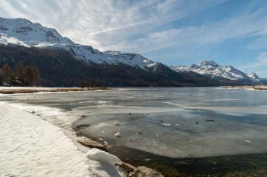 Silvaplana, Switzerland, February 21, 2023 Incredible winter panorama with a view over the frozen lake of Silvaplana and the snow covered summit of the mount Corvatsch in the background