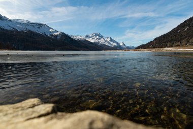 Silvaplana, Switzerland, February 21, 2023 Incredible winter panorama with a view over the frozen lake of Silvaplana and the snow covered summit of the mount Corvatsch in the background
