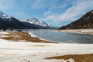 Silvaplana, Switzerland, February 21, 2023 Incredible winter panorama with a view over the frozen lake of Silvaplana and the snow covered summit of the mount Corvatsch in the background