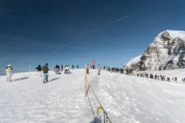 Jungfraujoch, Canton Bern, İsviçre, 11 Şubat 2023 Birçok insan güneşli bir kış gününde zirveye çıkıyor.