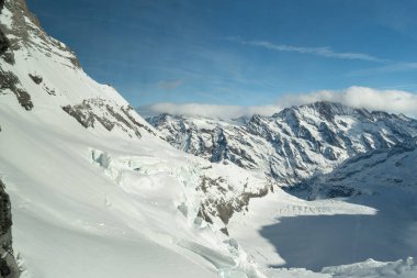 Eigergletscher, Canton Bern, İsviçre, 11 Şubat 2023 Güneşli bir günde kar kaplı alpler üzerinde inanılmaz güzel bir manzara bir pencereden çekilir.