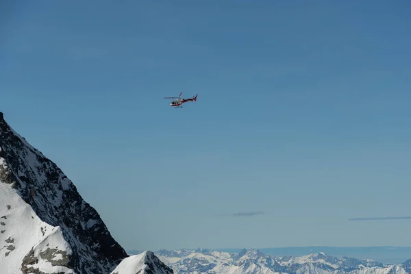 2023年2月11日スイスのカントン ベルン州ジュングフラウヨッホヘリコプターは晴れた日に雪に覆われた山々に沿って飛んでいます — ストック写真