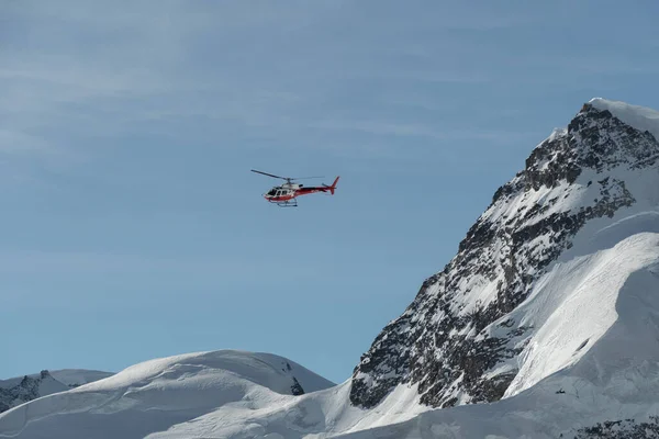 2023年2月11日 瑞士伯尔尼州荣格弗劳约市 一架直升机在阳光灿烂的一天沿着雪山飞行 — 图库照片